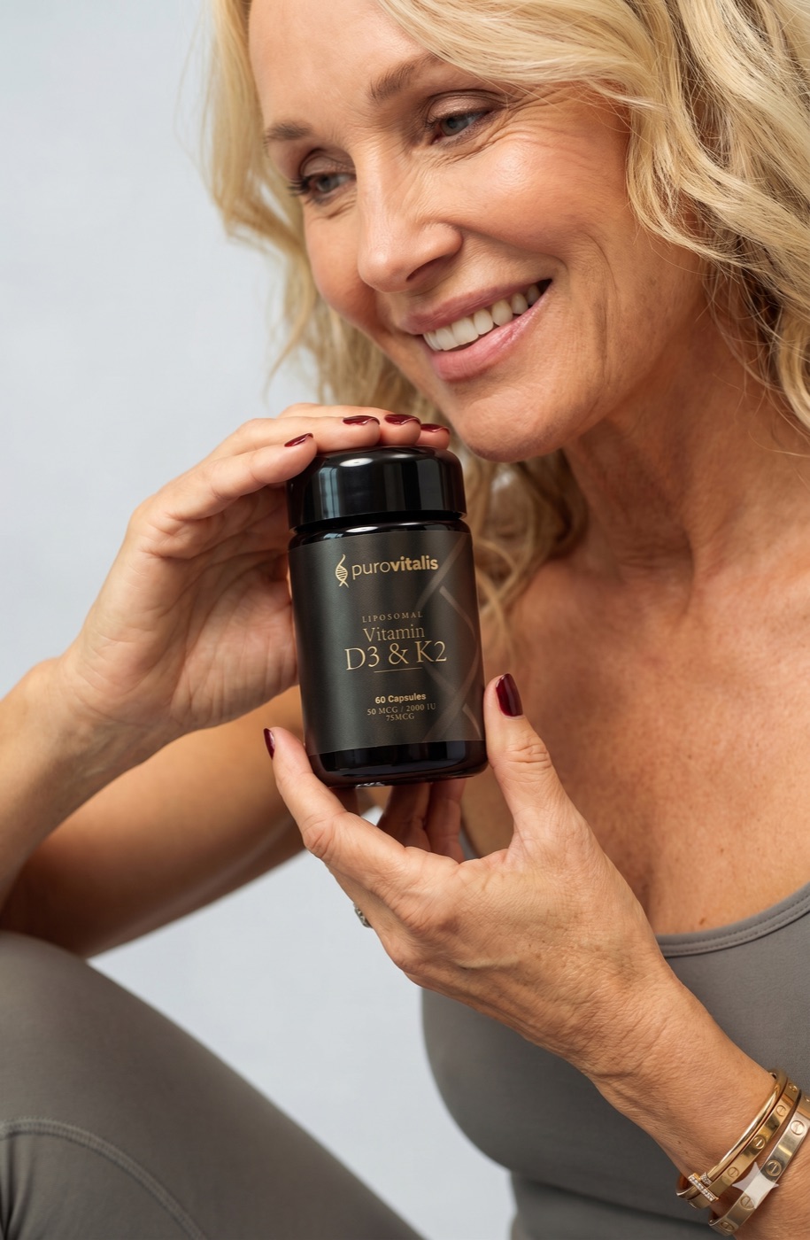 Woman holding a PuroVitalis liposomal Vitamin D3 and K2 supplement